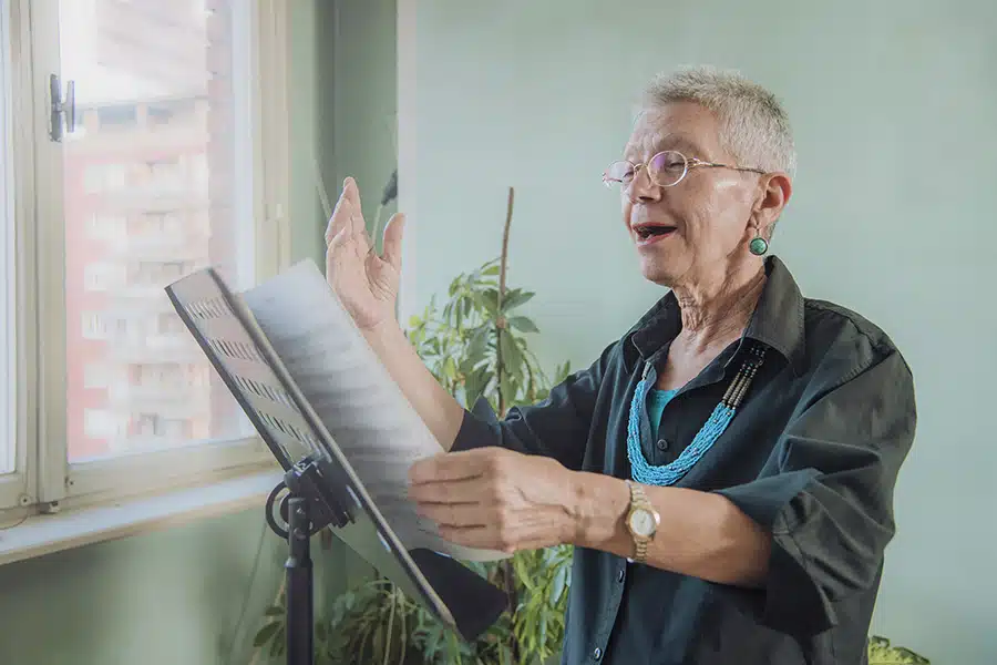 Older woman practices singing at home