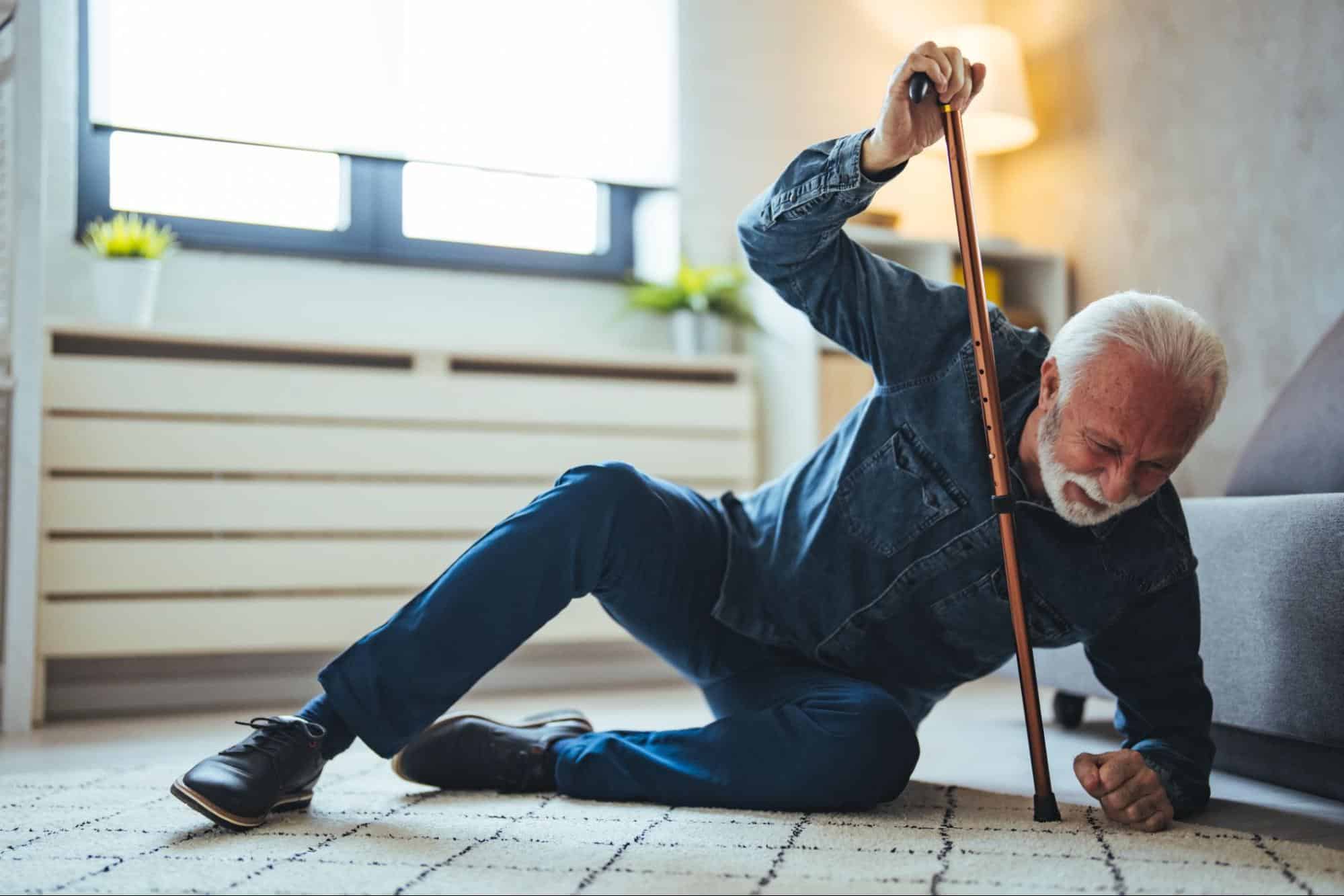 a man using a walking stick to help him up off the ground.