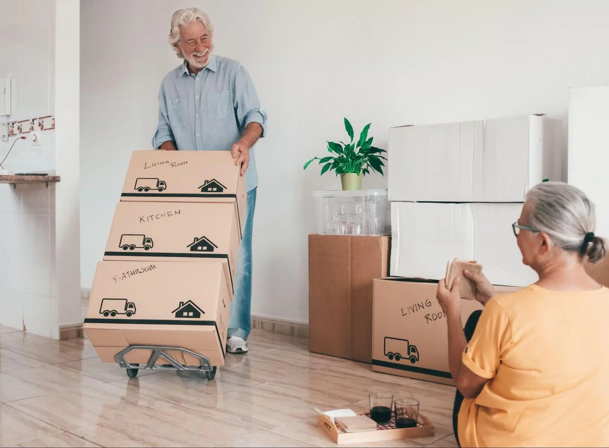 Senior pushing dolly of boxes in their new home