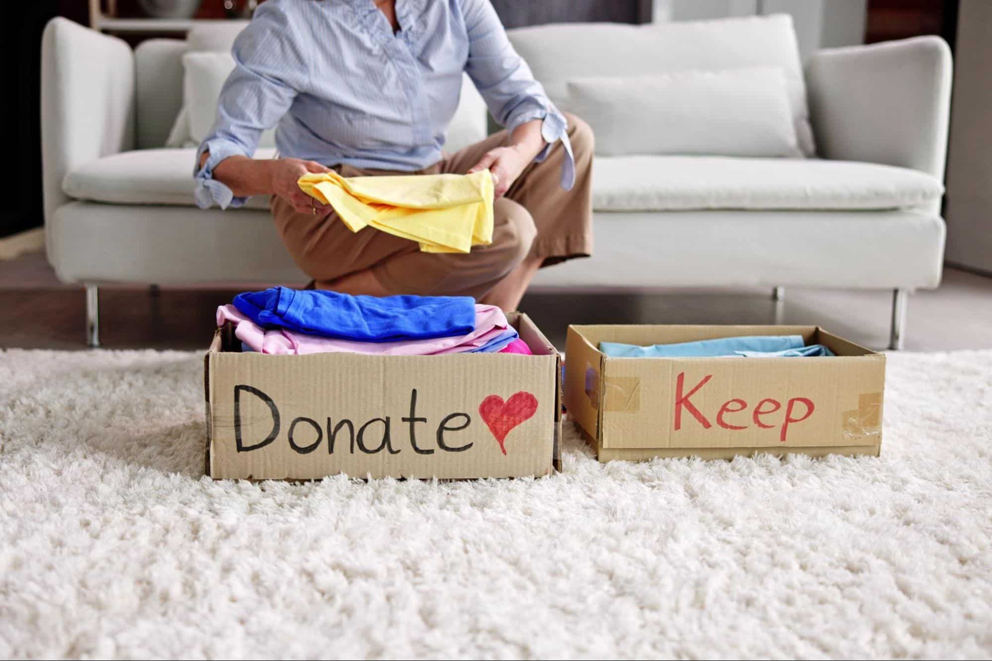 Senior organizing clothes into a donate and keep box
