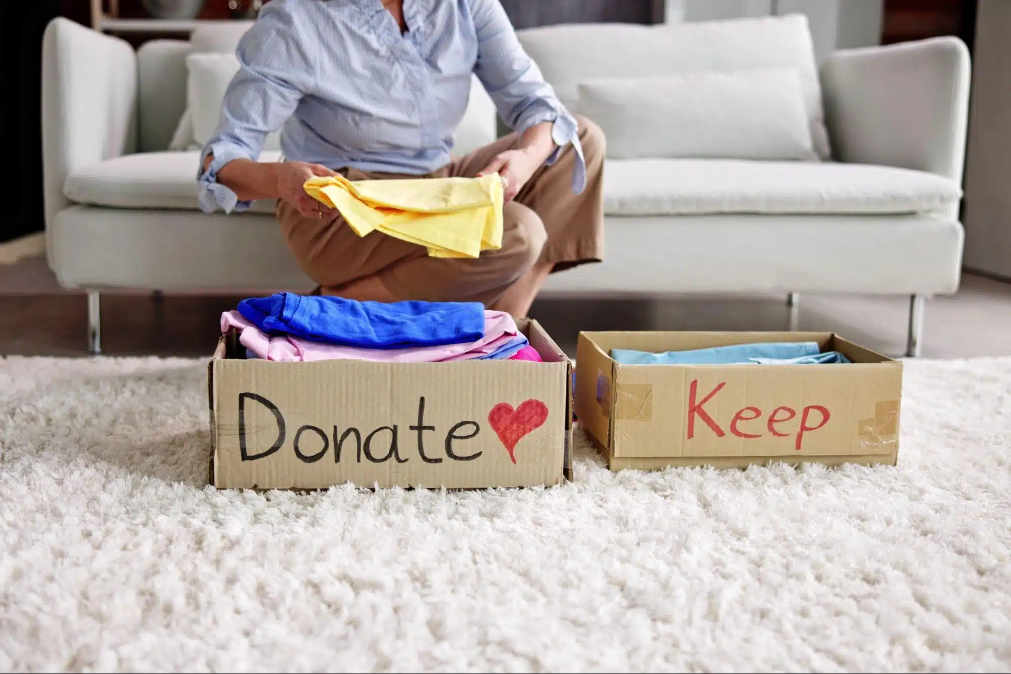 Senior organizing clothes into a donate and keep box