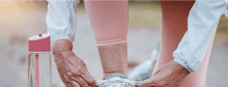 an elderly woman tying her shoes