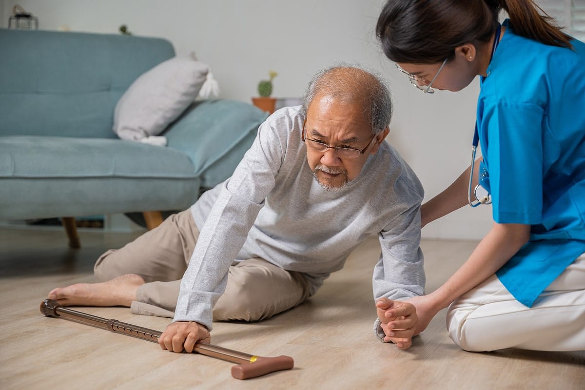 Nurse helping patient on floor