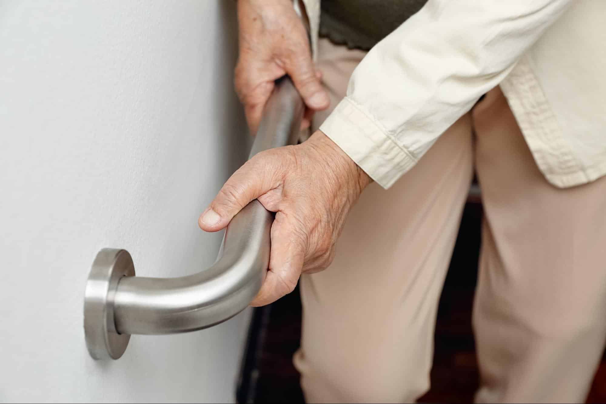 Senior holding onto rails