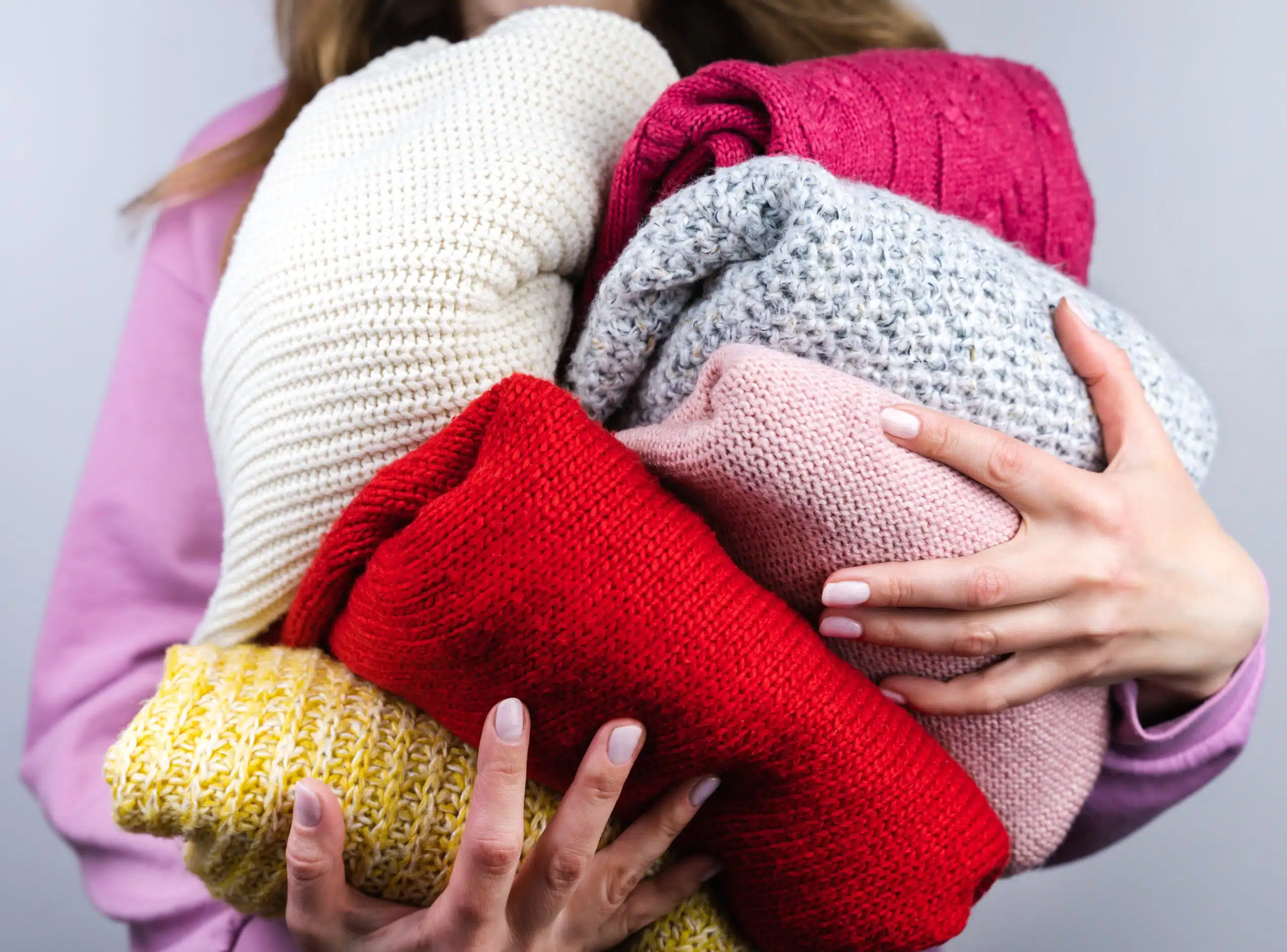 A stack of sweaters to depict proper layering in the winter for seniors